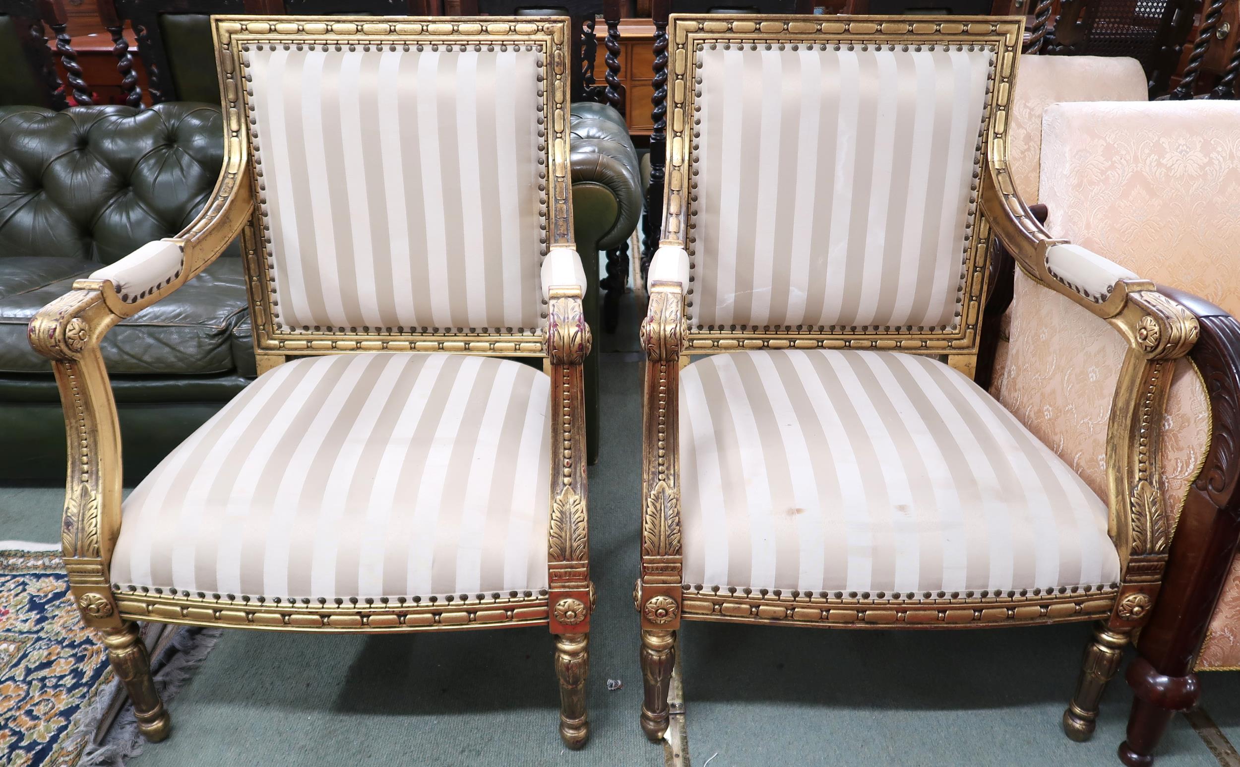 A pair of 20th century gilt framed continental style open armchairs with striped upholstery, 96cm