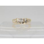 A 14k gold diamond ring, the central high prong set diamond is estimated approximately at 0.20cts