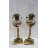 A pair of brass and glass oil lamps Condition Report:Available upon request