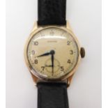 A 9ct gold vintage Garrard watch, inscribed verso, with a black leather strap, weight 30.3gms