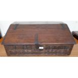 An 18th century oak bible box with sloped hinged top over carved relief "J H 1714", 26cm high x 69cm