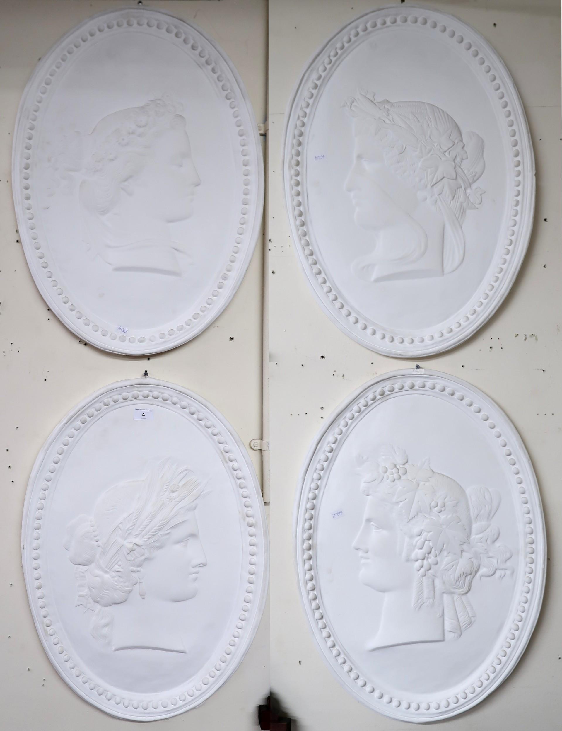 A set of four oval plaster wall plaques each with cameo style silhouettes in the guise of the four