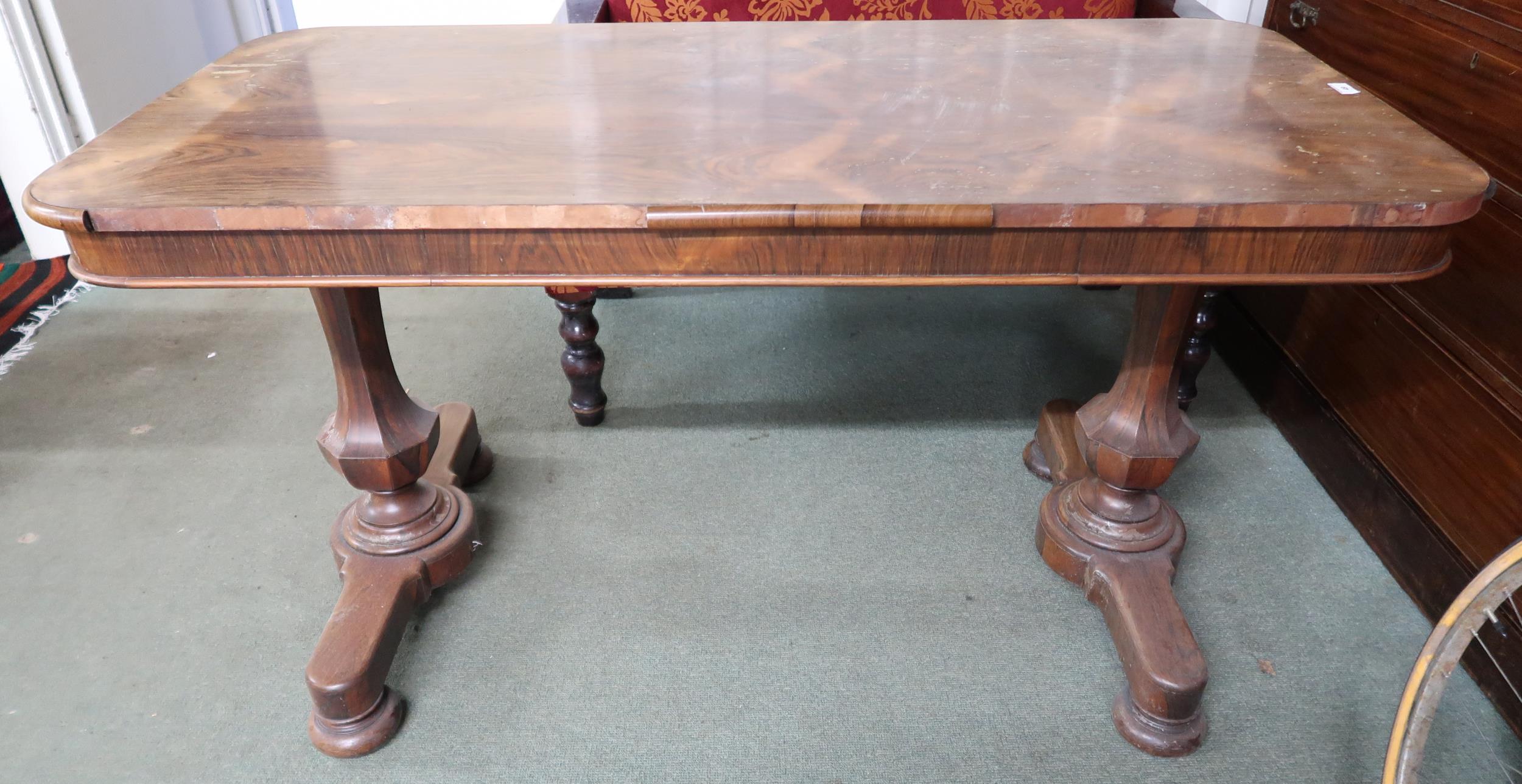 A Victorian rosewood library table with single drawer on octagonal baluster supports on bun feet,