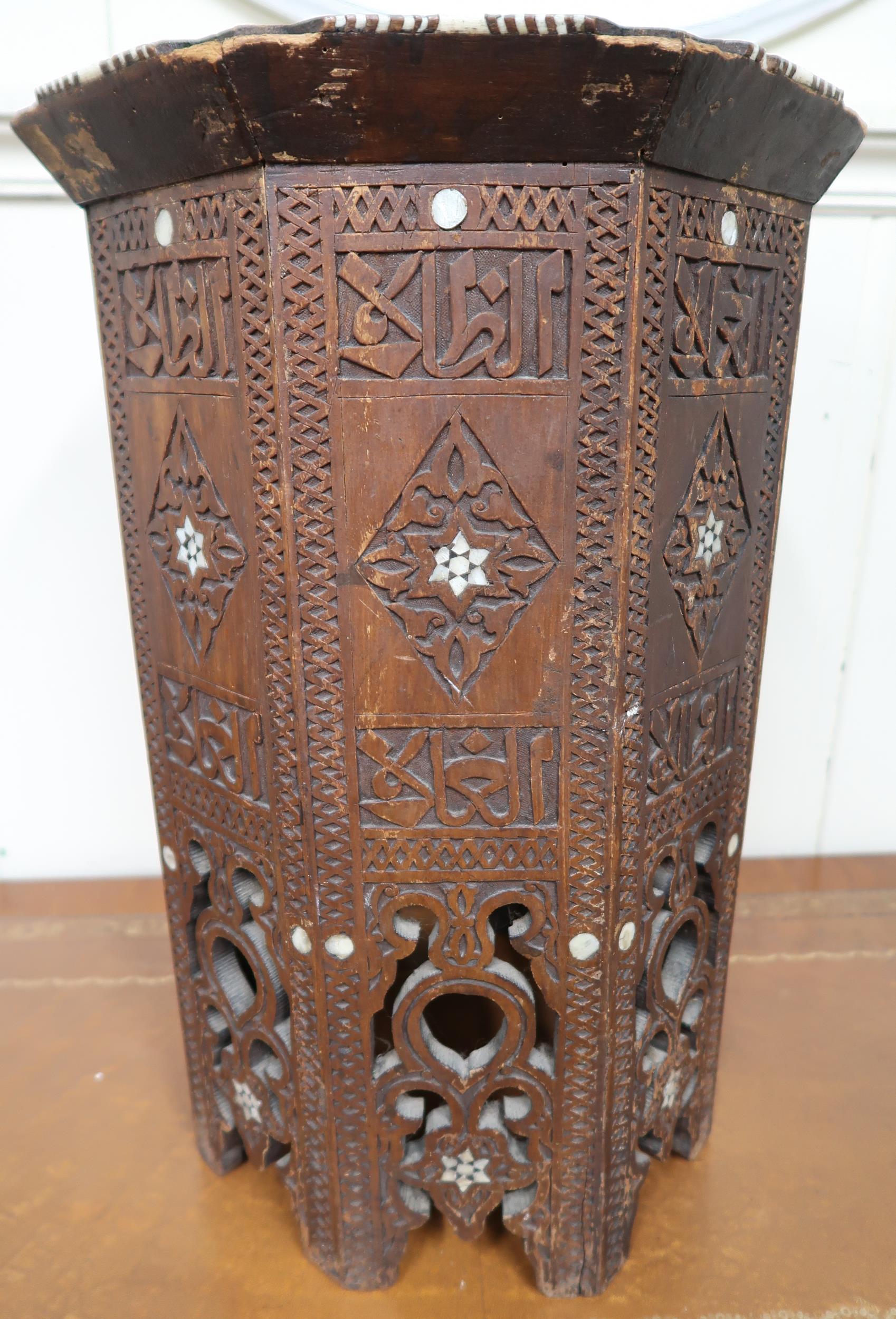 A 19th century Moorish occasional table with carved octagonal top with bone inlaid edges over carved