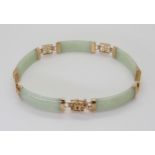 A 9ct gold mounted Chinese green hardstone bracelet, with Chinese symbols, length 19cm, weight 10.