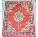A red ground Keshan style rug with beige central medallion, matching spandrels and multicoloured