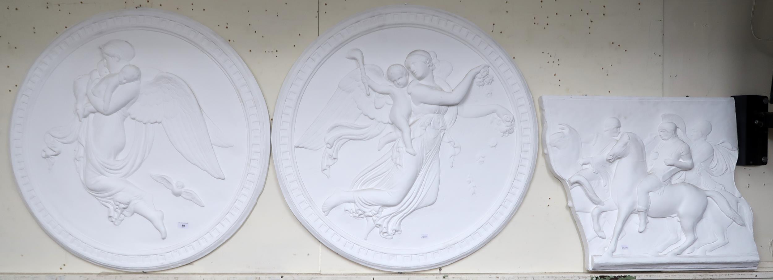 A pair of circular plaster wall plaques depicting angels in flight, 92cm diameter and another