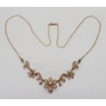 an Early 20th Century yellow metal and pearl set flower necklace, the back inscribed with initials