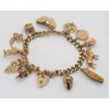 A 9ct gold charm bracelet with heart shaped clasp and 12 attached 9ct gold hallmarked charms, weight
