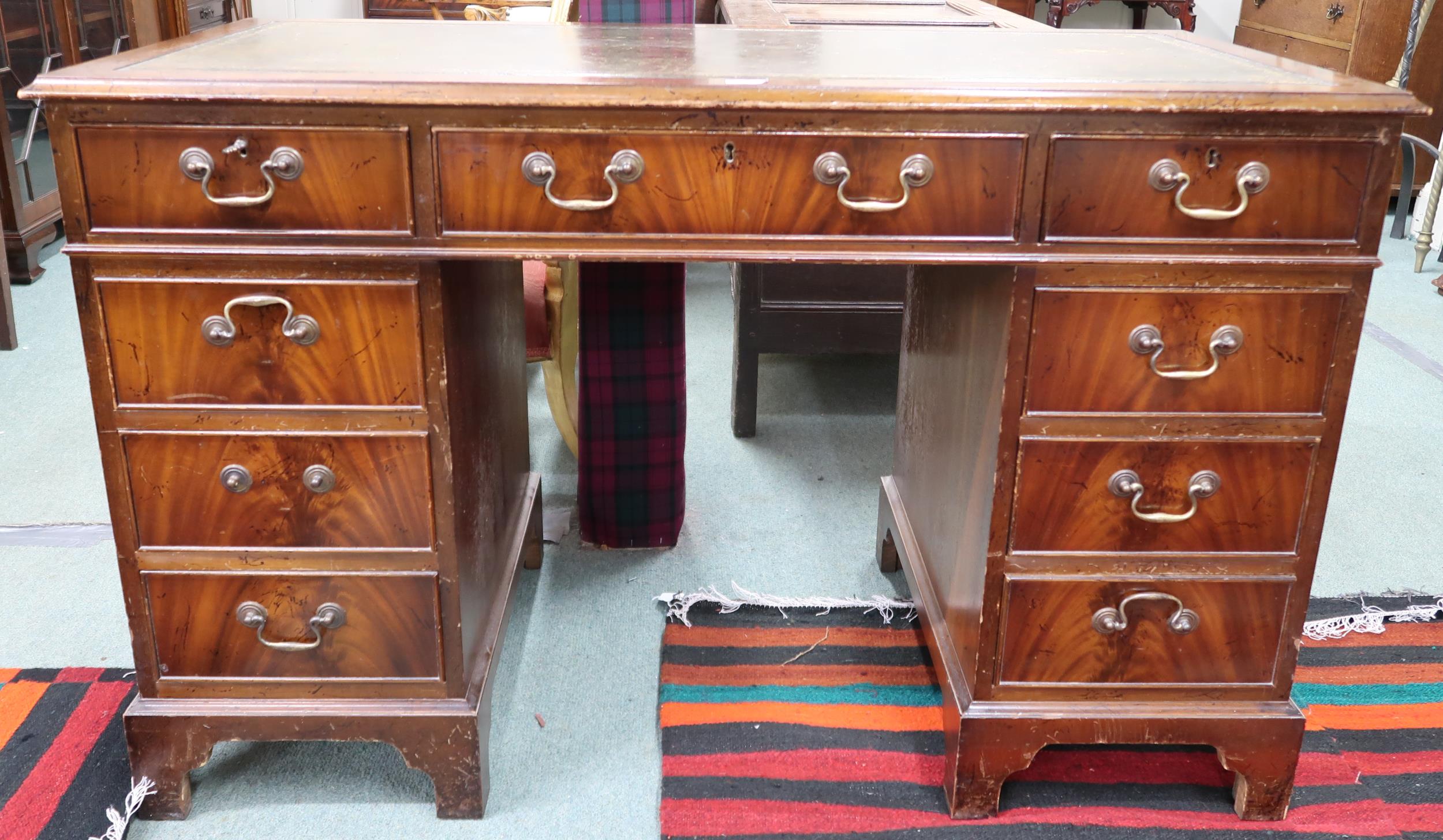 A 20th century mahogany pedestal writing desk with green leather skiver over single drawer flanked