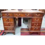 A 20th century mahogany pedestal writing desk with green leather skiver over single drawer flanked