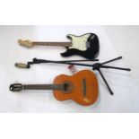 A classical nylon strung acoustic guitar and a Squire Stratocastor electric guitar (af) Condition