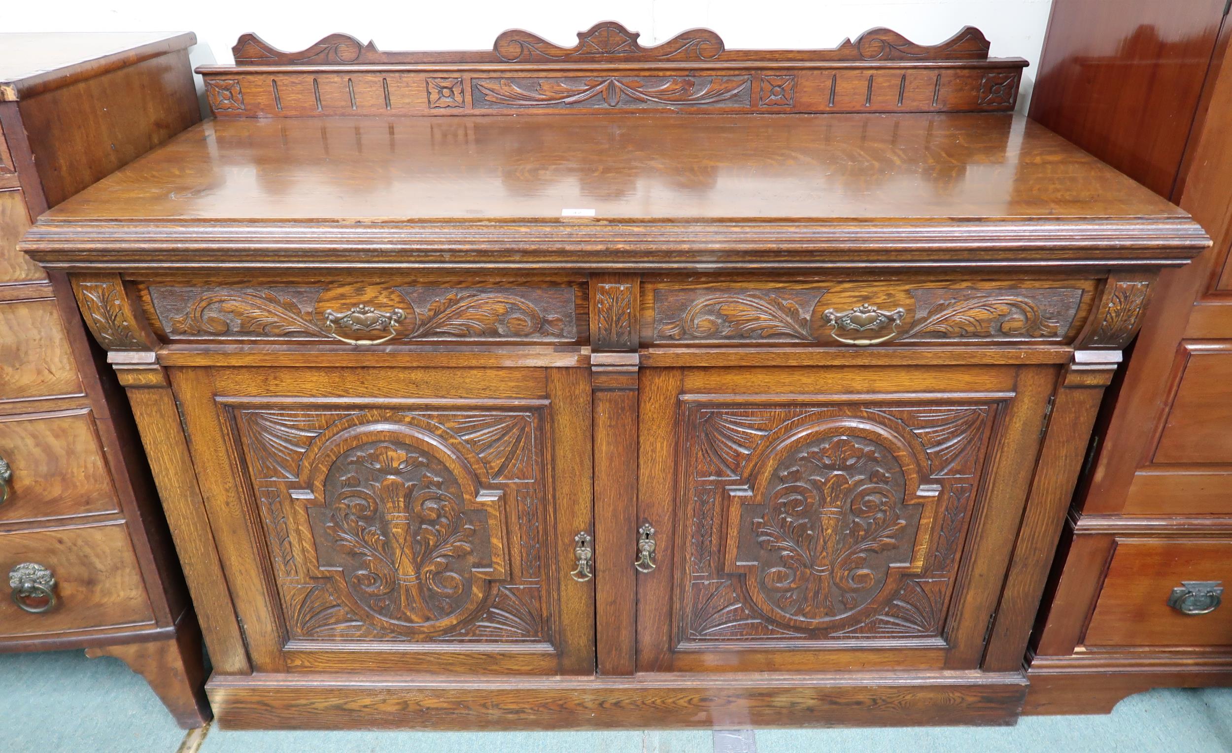 A Victorian oak sideboard with pair of carved drawers over pair of carved doors on plinth base, 99cm