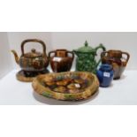 A collection of Dunmore pottery including a teapot on stand, bread plate, moulded green glazed