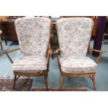 A pair of mid 20th century Ercol elm and beech framed open armchairs with floral foliate upholstery,