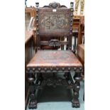 A Victorian stained oak framed Baronial style hall chair with leather back and seat embossed with