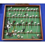 A display of largely reproduction clay pipes, together with a desktop pipe rack supporting mixed