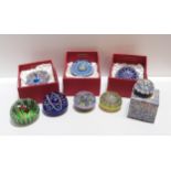 Eight Perthshire glass paperweights including millefiori, flowers and a candle Condition Report: