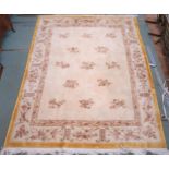 A cream ground Oriental style rug with mustard edged floral borders, 320cm long x 245cm wide