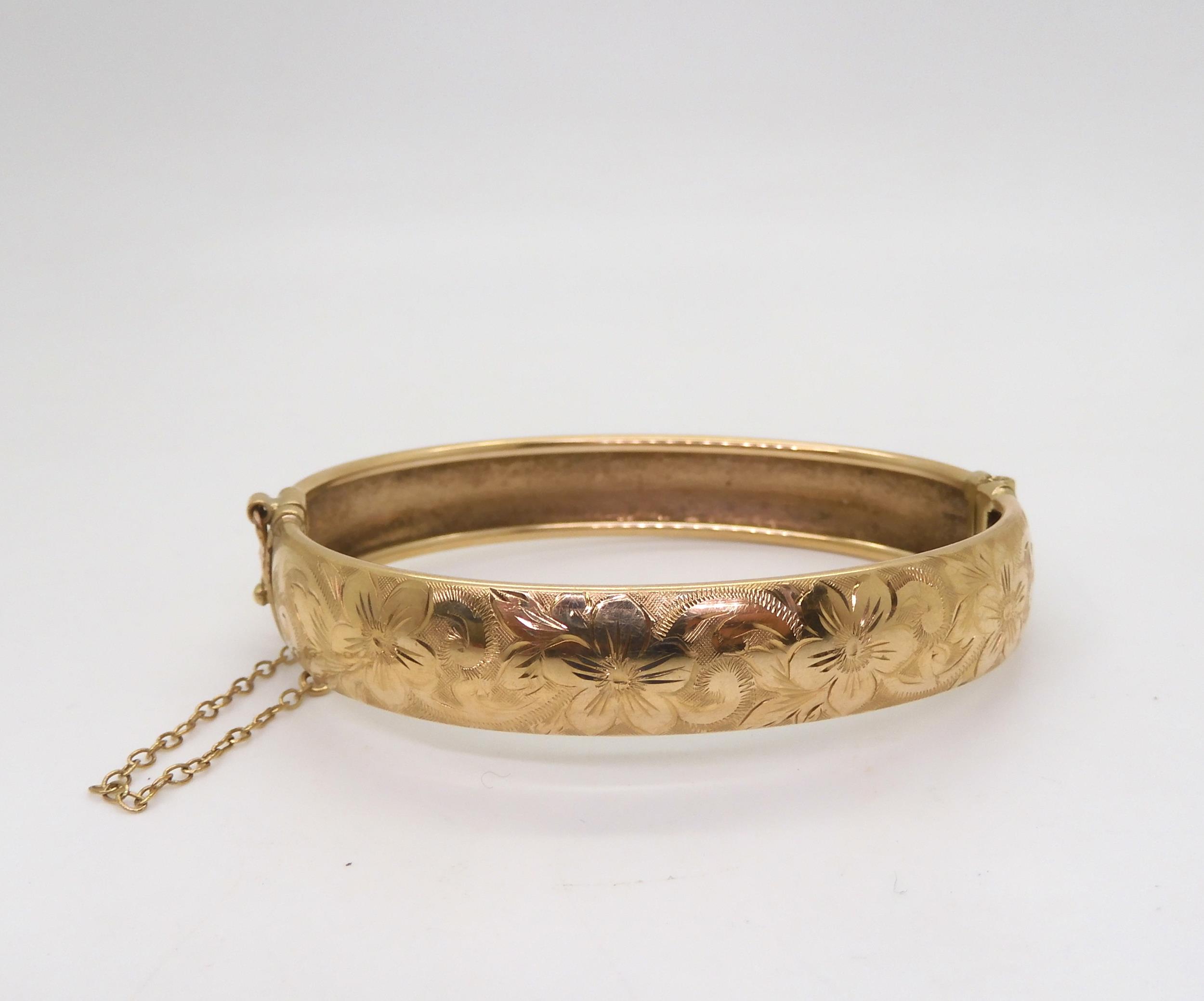 A 9ct gold flower engraved bangle, inner diameter 6.5cm, weight 17.6gms Condition Report:Available