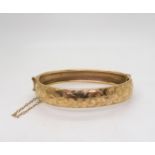 A 9ct gold flower engraved bangle, inner diameter 6.5cm, weight 17.6gms Condition Report:Available
