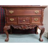 A 20th century mahogany lowboy style chest of drawers with one long over three short drawers on ball