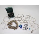 A silvercharm bracelet with attached silver and white metal charms and coins, a silver bangle, and