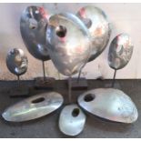 A lot of seven graduating stainless steel sculptures and a lacquered urn (8) Condition Report: