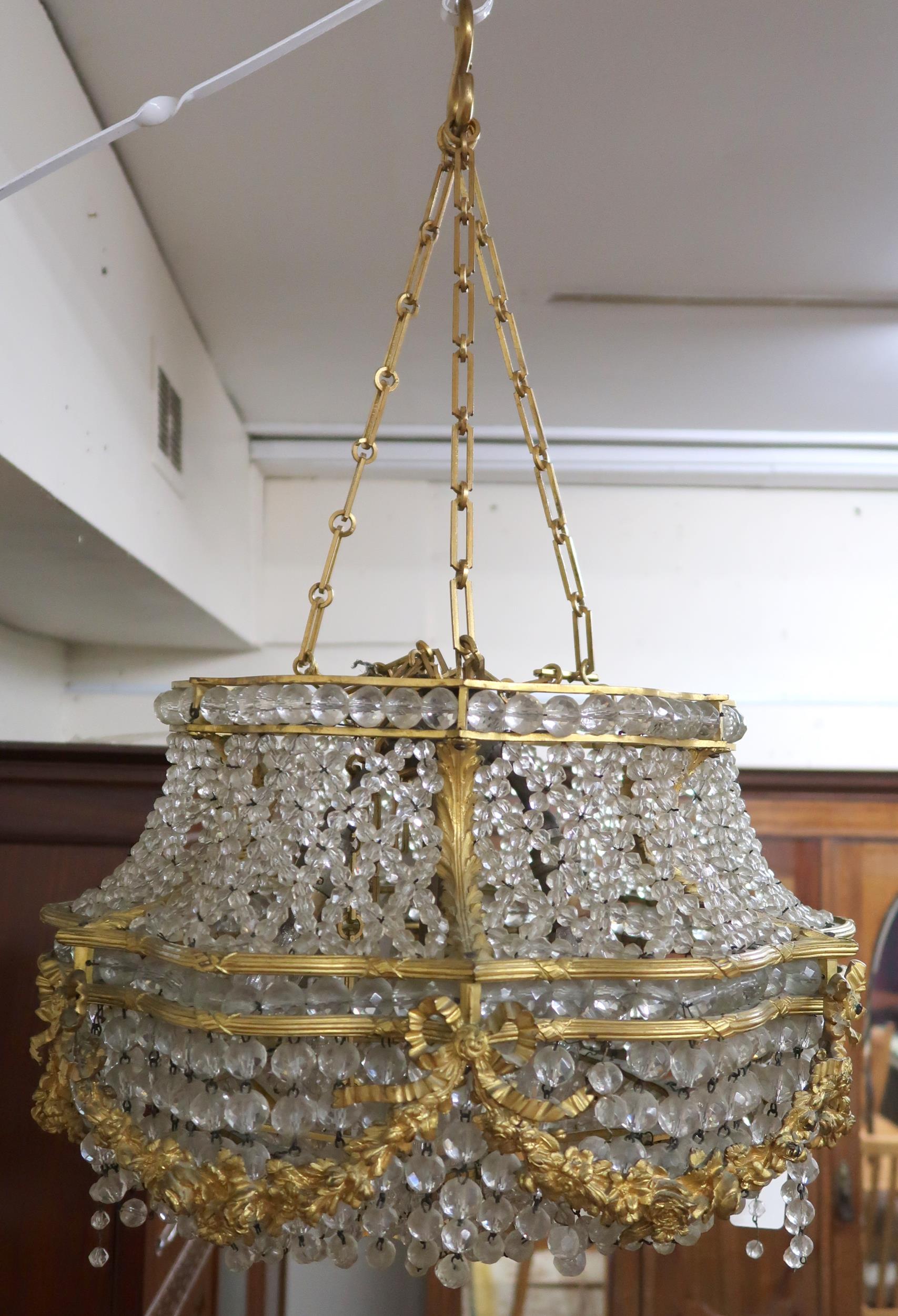 An early 20th century Louis XVI style basket chandelier with cast brass floral swags joined by