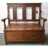 A 20th century oak open hall settle with hinged seat on turned feet, 113cm high x 109cm wide x