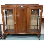 A 20th century mahogany glazed display cabinet with central bow fronted cabinet door flanked by