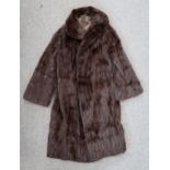 A brown fur coat, a fox stole, a crocodile skin handbag and a patchwork quilt Condition Report:No