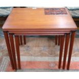 A mid 20th century teak Danish nest of three tables, the largest one inlaid with tiles, 50cm high