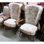 A pair of mid 20th century Ercol elm and beech open armchairs with floral foliate upholstery,