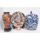 An Imari porcelain vase decorated with a phoenix and bamboo, a charger, a small vase and lidded blue