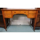 An early 20th century serpentine front writing desk with leather skiver over single long drawer