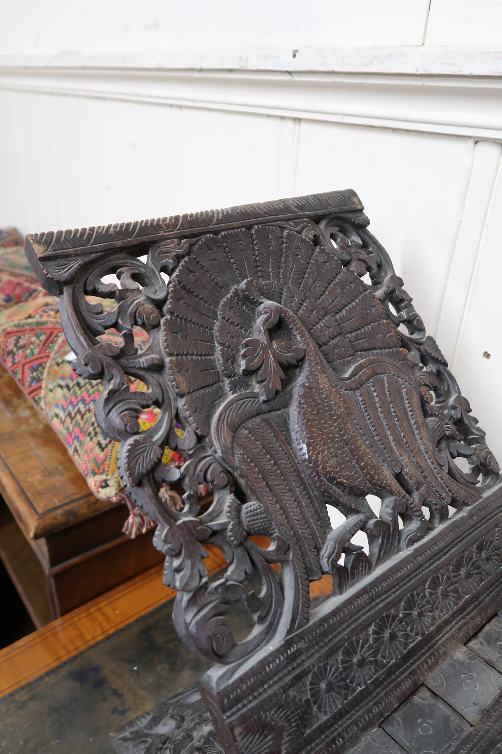 An early 20th century Burmese style folding stool extensively carved with peacocks, a carved game - Image 4 of 6