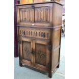 A 20th century oak linen fold drinks cabinet with fall front drinks compartment over single drawer