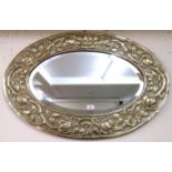 An early 20th century British brass framed oval wall mirror with frame embossed with rose heads