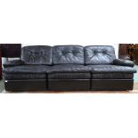 A mid 20th century after Tetrad sectional three seater sofa with black patchwork leather upholstery,