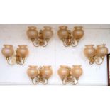 A set of six 20th century brass two branch wall sconces with scroll decorated arms with opaque glass