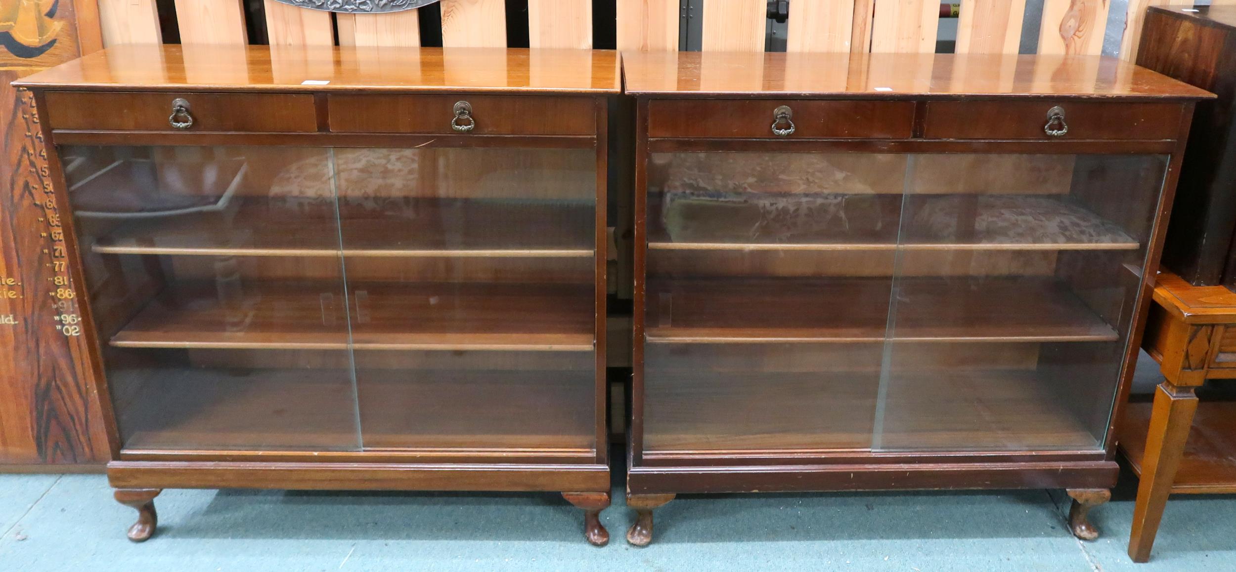 A pair of 20th century stained teak bookcases with pair of drawers over glass sliding doors, 90cm