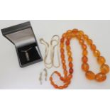 A string of amber coloured beads, weight 94.1gms approx, together with a silver Mackintosh style