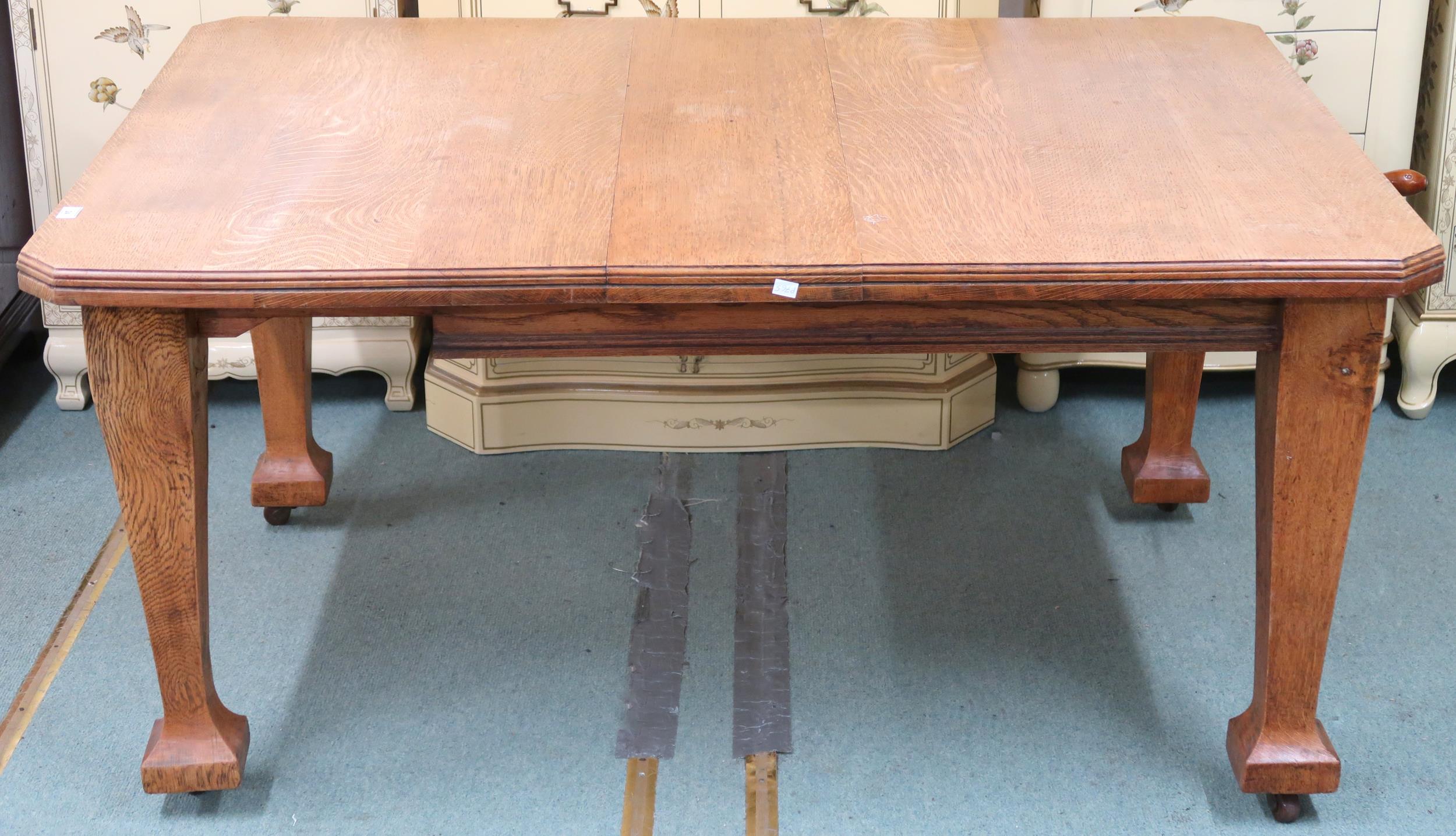 A late Victorian oak arts and crafts style wind out extending dining table with two leaves (one