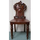 A Victorian stained oak court chair with carved armorial splat over shaped seat on turned front