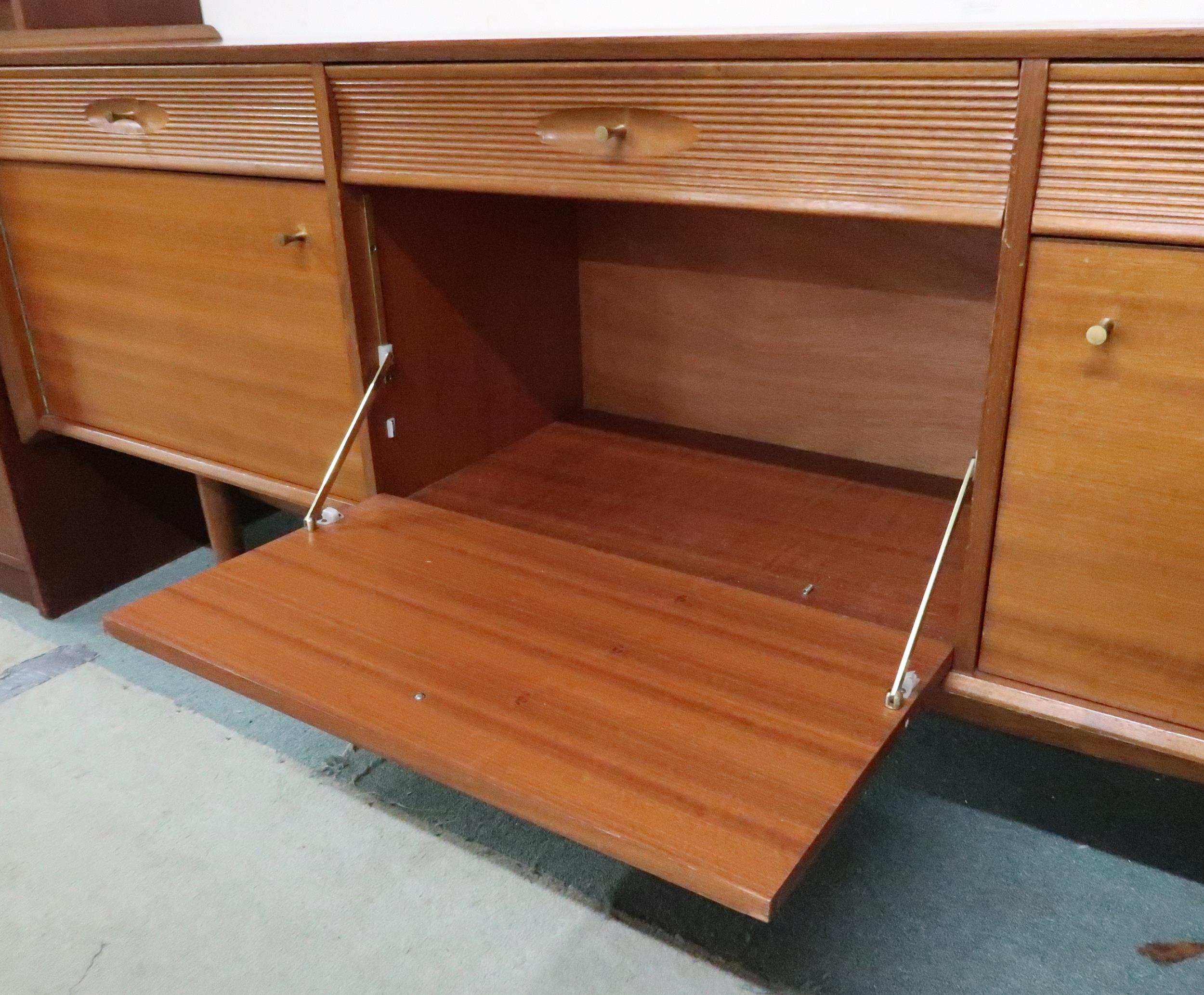 A mid 20th century teak sideboard with three drawers over central fall front compartment flanked - Image 5 of 8