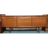 A mid 20th century teak sideboard with three drawers over central fall front compartment flanked