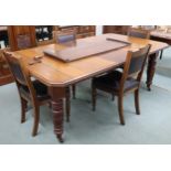 A Victorian oak wind out extending dining table on turned supports terminating in ceramic casters,