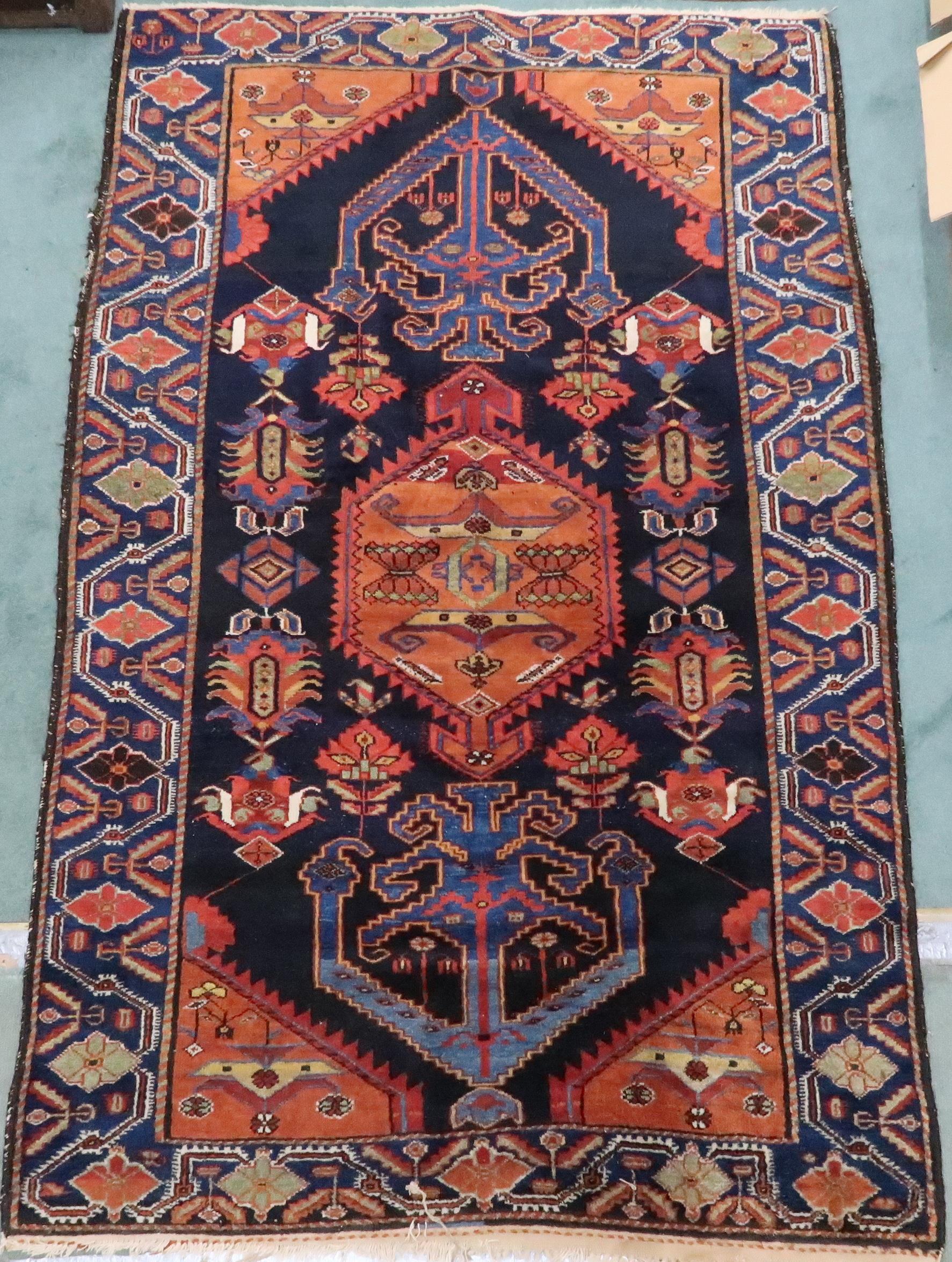 A dark blue ground Hamadan rug with terracotta geometric central medallion, matching spandrels and