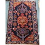 A dark blue ground Hamadan rug with terracotta geometric central medallion, matching spandrels and